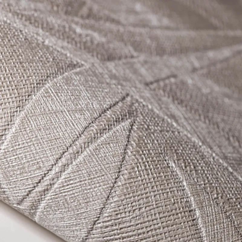Modern non-woven wallpaper with linen texture and tropical leaf pattern in square blocks in light beige/cream tones