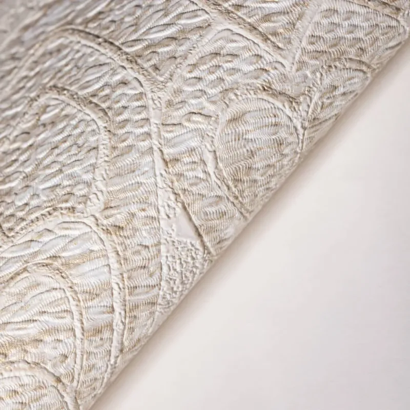 Luxurious non-woven wallpaper with embossed damask pattern in light cream/beige tones